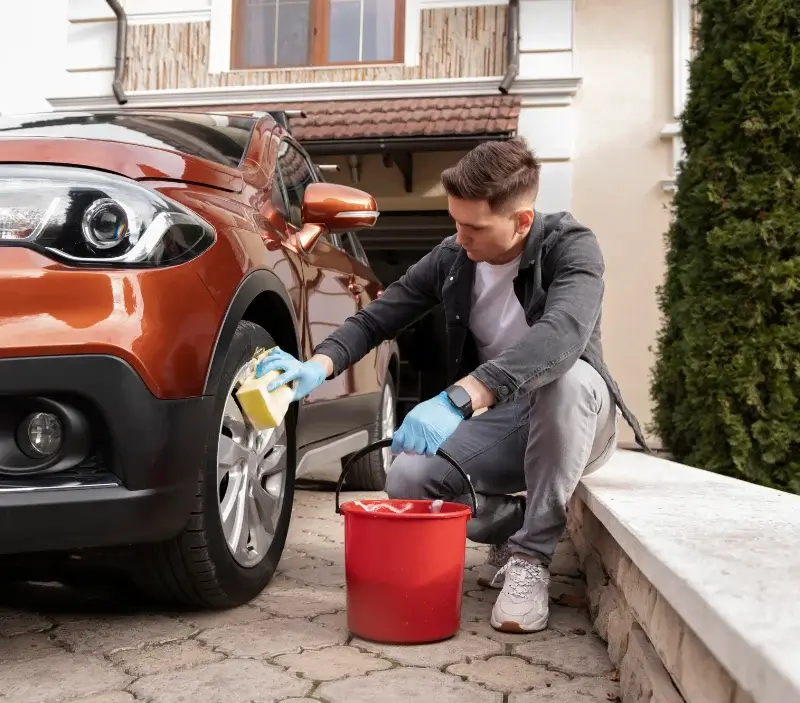 Lavage auto à domicile Fontaine-la-Guyon : professionnel intervenant sur un véhicule